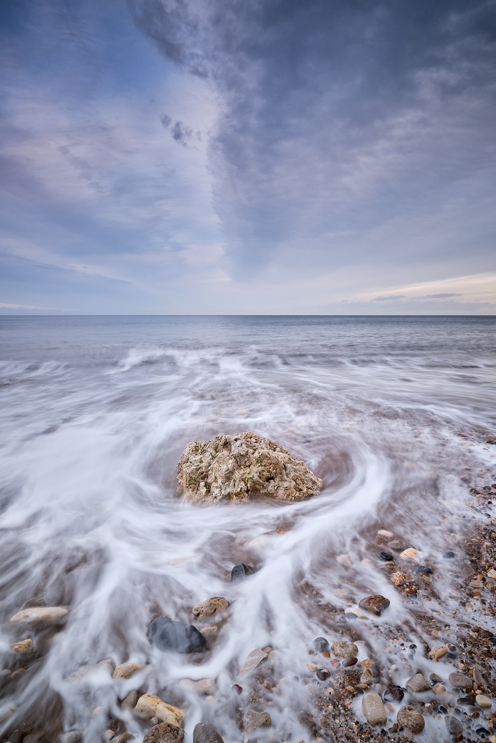 Rock surrounded by swirling incoming tide on Easington beach
