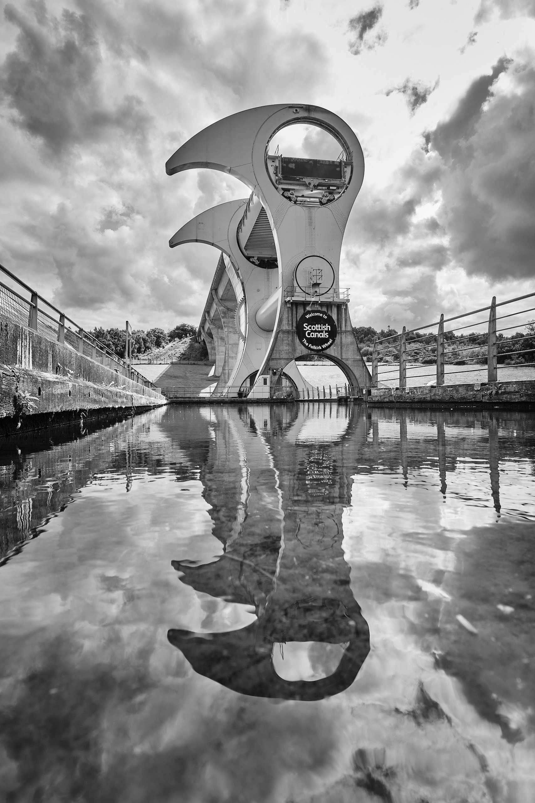 Falkirk Wheel boat lift in black and white, reflected in the canal basin